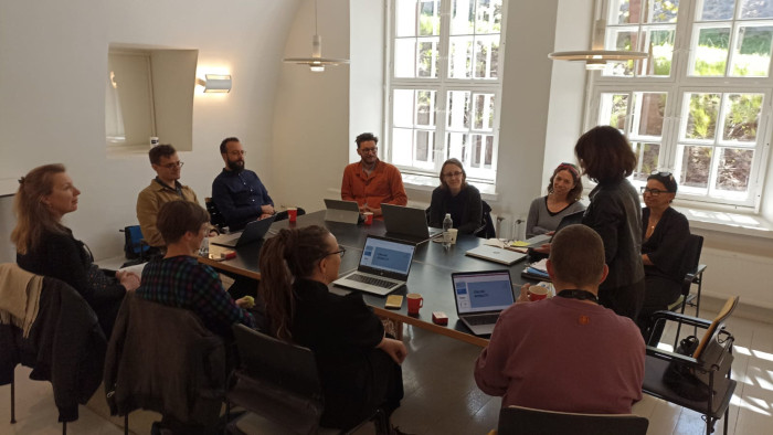 A dozen or so people sitting around a conference table at a presentation on digital mobility.