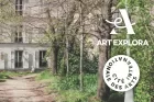 A dirt path, with trees at the side, leading to the residency building of the Cité internationale des arts.