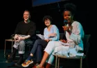 Three seated people laughing during an onstage Q&A or discussion.