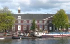 Exterior shot of Hermitage Amsterdam - a long, low brick building facing onto a canal, and a branch of the Hermitage Museum of Saint Petersburg.