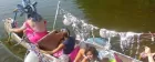 Colourful partygoers paddling in a canoe.